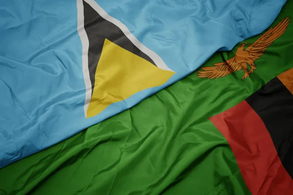 waving colorful flag of zambia and national flag of saint lucia. macro