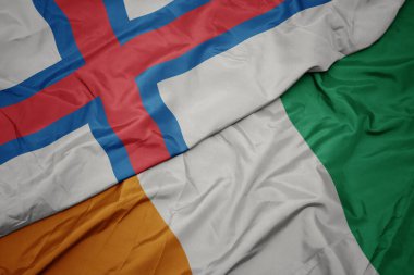 Cote Divoire 'ın renkli bayrağı ve Faroe Adaları' nın ulusal bayrağı sallanıyor. makro