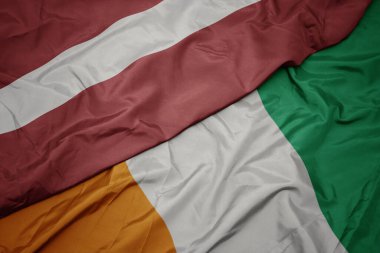 Cote Divoire 'ın renkli bayrağı ve Letonya' nın ulusal bayrağı sallanıyor. makro