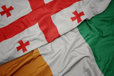 Cote Divoire 'ın renkli bayrağı ve Georgia' nın ulusal bayrağı sallanıyor. makro