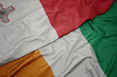 Cote Divoire 'ın renkli bayrağı ve Malta' nın ulusal bayrağı sallanıyor. makro