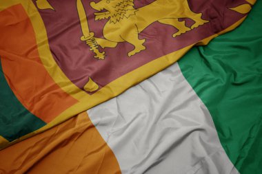 Cote Divoire 'ın renkli bayrağı ve Sri Lanka' nın ulusal bayrağı sallanıyor. makro