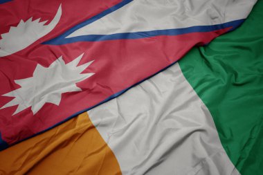 Cote Divoire 'ın renkli bayrağı ve Nepal' in ulusal bayrağı sallanıyor. makro