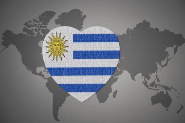 Dünya haritasının arka planında Uruguay 'ın ulusal bayrağı olan bir bulmaca kalbi. 3B illüstrasyon