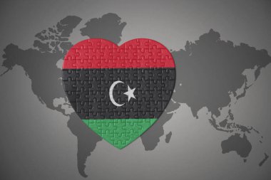 Dünya haritasının arka planında ulusal libya bayrağı olan bir bulmaca kalbi. 3B illüstrasyon