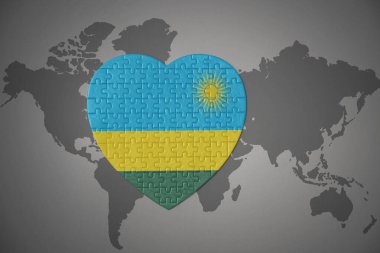 Ruanda 'nın ulusal bayrağını taşıyan bir yapboz kalbi dünya haritasının arka planında. 3B illüstrasyon