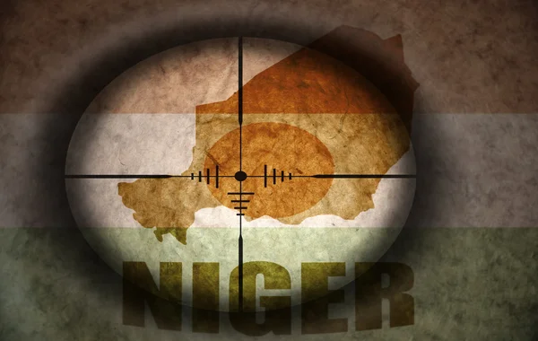 Снайперский прицел, нацеленный на винтажный нигерский флаг и карту — стоковое фото