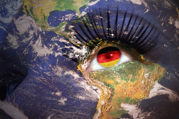 Woman's face with planet Earth texture and german flag inside the eye — Stock Photo, Image