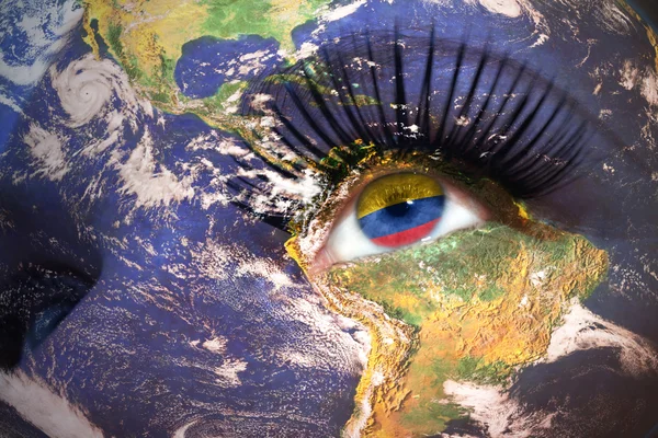 Cara de mujer con la textura del planeta Tierra y bandera colombiana dentro del ojo . — Foto de Stock