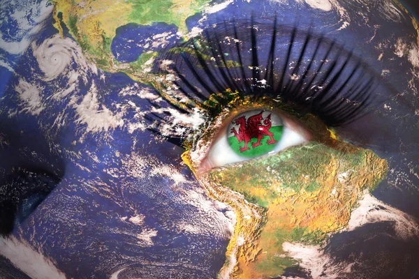 Woman's  face with planet Earth texture and welsh flag inside the eye. — Stock Photo, Image