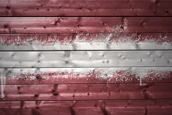 Pintado bandeira letã em uma textura de madeira — Fotografia de Stock