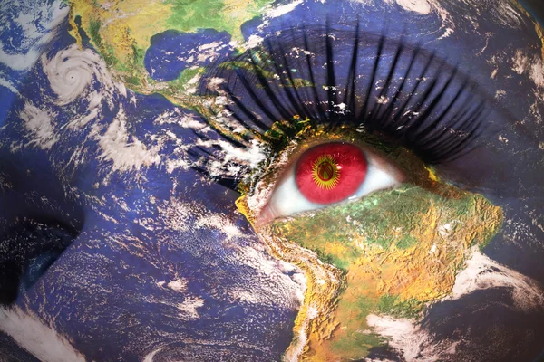 Womans face with planet Earth texture and kyrgyzstan flag inside the eye — Zdjęcie stockowe