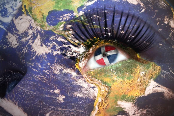 Женщины сталкиваются с планетой Земля текстурой и флагом Доминиканской республики внутри глаза — стоковое фото