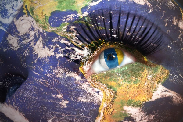 Woman's face with planet Earth texture and canarian flag inside the eye. — Stockfoto