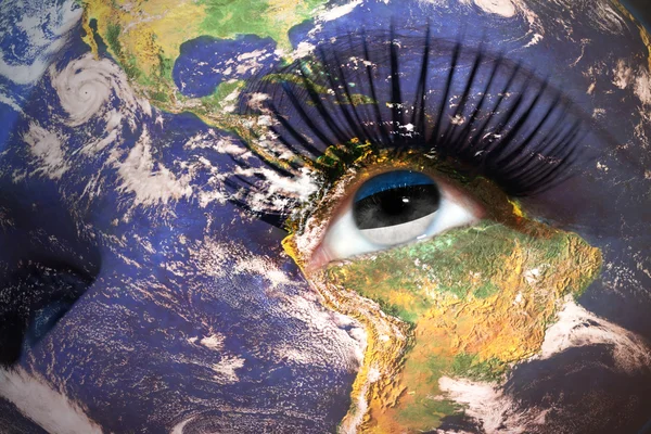 Woman's face with planet Earth texture and estonian flag inside the eye. — Stockfoto