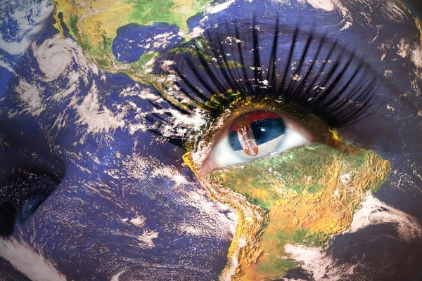 Woman's face with planet Earth texture and serbian flag inside the eye. — ストック写真