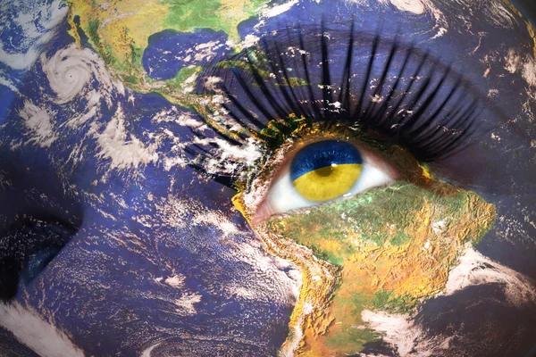 Cara de mujer con la textura del planeta Tierra y bandera ucraniana dentro del ojo . — Foto de Stock