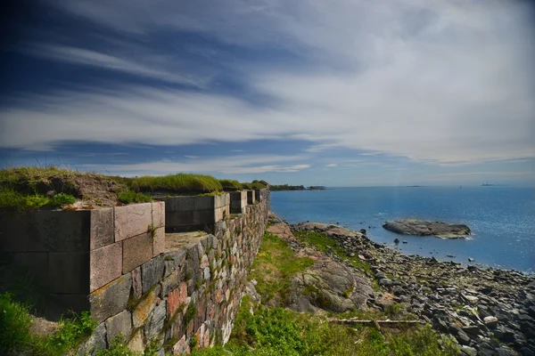 Antigua fortaleza bajo cielos azules y dramáticos en la orilla del mar — Foto de Stock