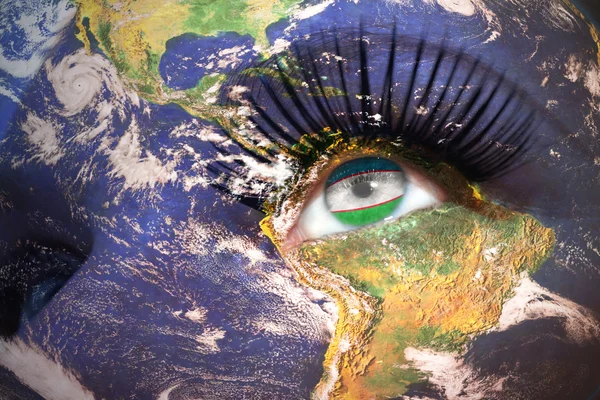 Womans face with planet Earth texture and uzbekistan flag inside the eye. — Stock Photo, Image