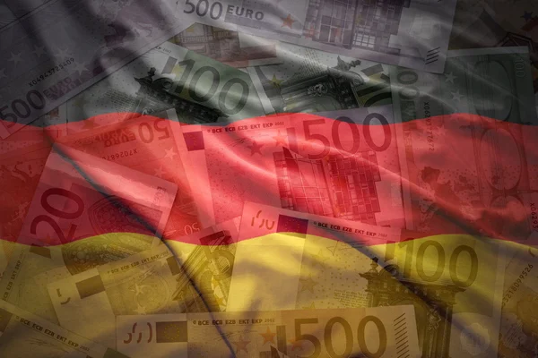 Colorful waving german flag on a euro money background — Stockfoto