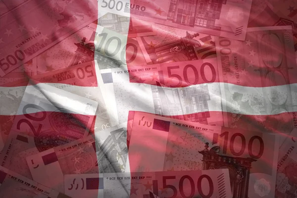 Colorful waving danish flag on a euro money background — Stockfoto