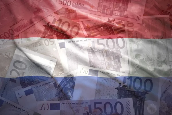 Colorful waving dutch flag on a euro money background — Stock Photo, Image