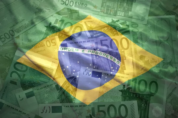 Colorful waving brazilian flag on a euro money background — Stockfoto