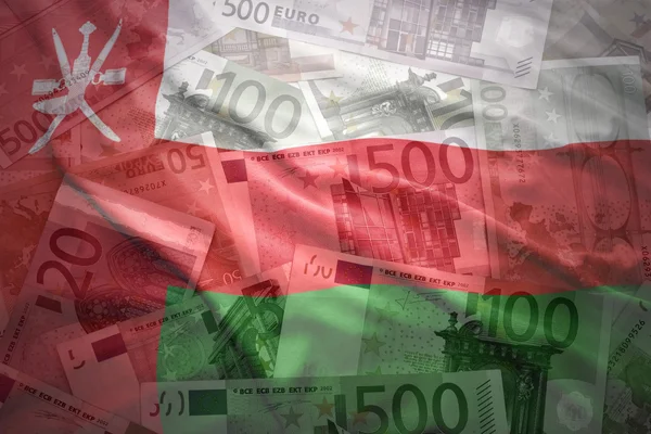 Bandera omani ondeando colorido sobre un fondo de dinero en euros — Foto de Stock