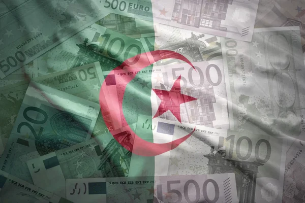 Colorful waving algerian flag on a euro money background — ストック写真