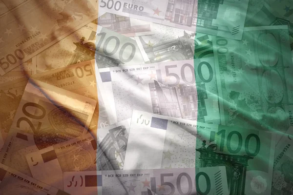 Colorful waving ivorian flag on a euro money background — Stockfoto