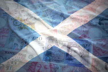 colorful waving scottish flag on a english pound sterling money background