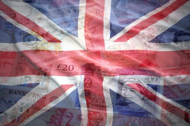 colorful waving british flag on a english pound sterling money background