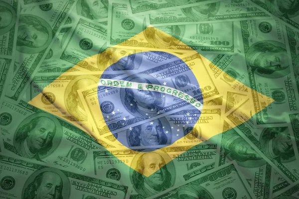 Colorful waving brazilian flag on a american dollar money background — Stok fotoğraf