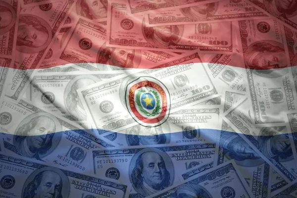 Colorido acenando bandeira paraguaia em um fundo de dinheiro dólar americano — Fotografia de Stock