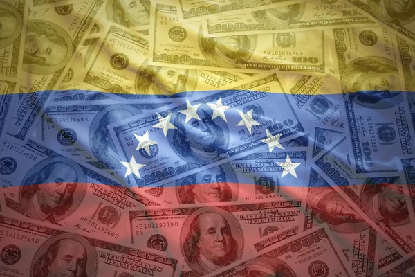 colorful waving venezuelan flag on a american dollar money background
