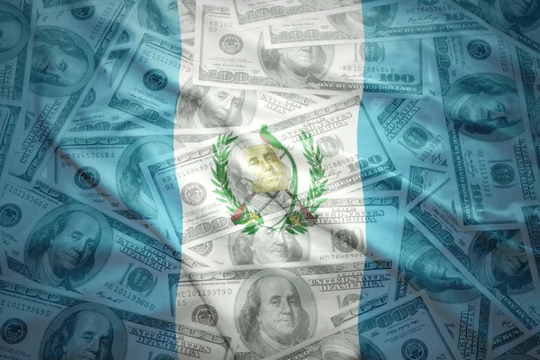 Colorful waving guatemalan flag on a american dollar money background — 图库照片