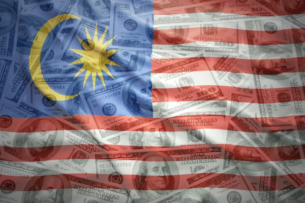 Colorful waving malaysian flag on a american dollar money background — ストック写真