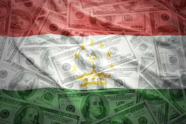 Colorful waving tajik flag on a american dollar money background — Stockfoto