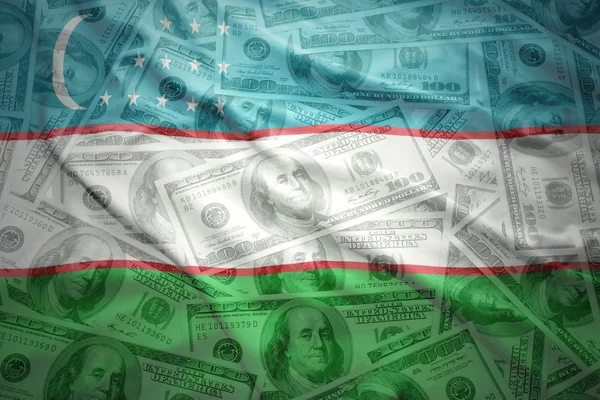 Colorful waving uzbek flag on a american dollar money background — Stok fotoğraf
