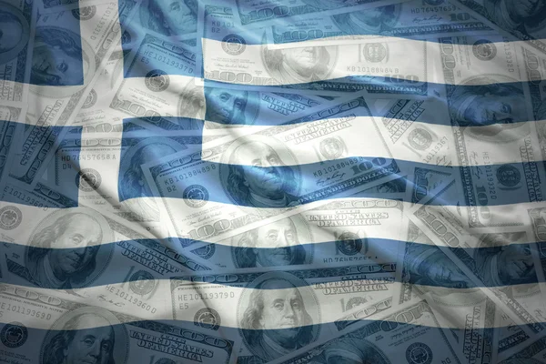 Размахивая греческим флагом на американских долларах — стоковое фото