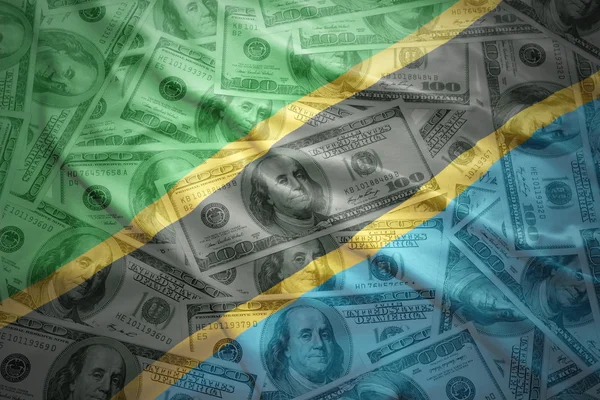 Drapeau tanzanien agitant coloré sur un fond d'argent dollar américain — Photo