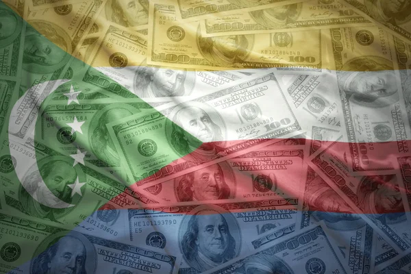 Amerikan Doları para arka plan üzerinde renkli sallanan Komor bayrağı — Stok fotoğraf