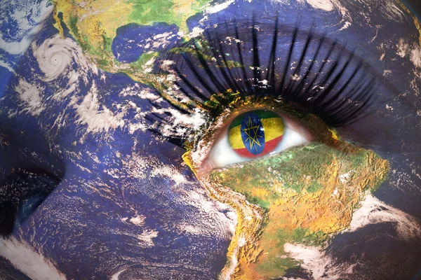 Womans twarz z planety Ziemia tekstury i flagi Etiopii wewnątrz oka. — Zdjęcie stockowe