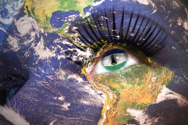 Donne faccia con il pianeta Terra texture e bandiera lesotho all'interno dell'occhio . — Foto Stock