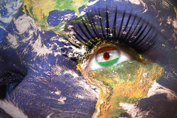 Kvinnans ansikte med planeten jorden textur och niger flagga inne i ögat. — Stockfoto