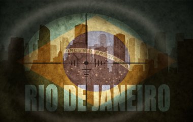 sniper scope aimed at the abstract silhouette of the city with text Rio de Janeiro at the vintage brazilian flag