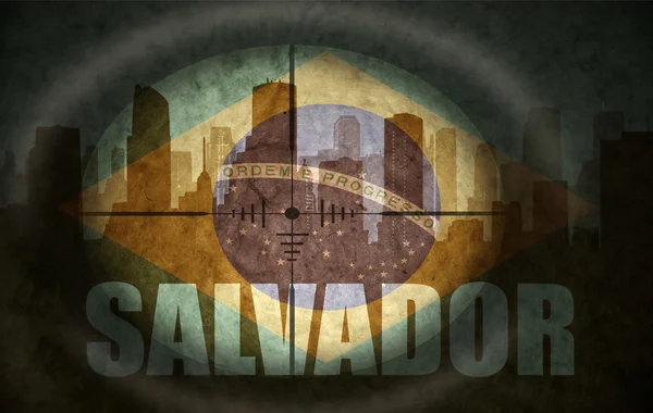 Sniper scope aimed at the abstract silhouette of the city with text Salvador at the vintage brazilian flag — Stock fotografie