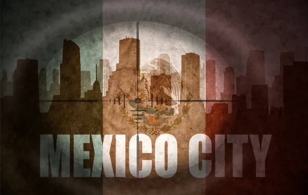 Sniper scope aimed at the abstract silhouette of the city with text Mexico City at the vintage mexican flag — Stock Fotó