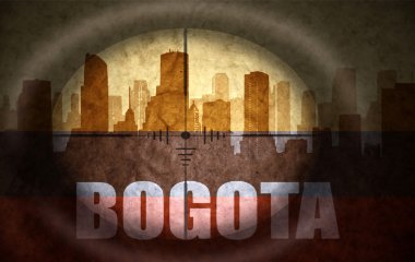 sniper scope aimed at the abstract silhouette of the city with text Bogota at the vintage colombian flag. concept