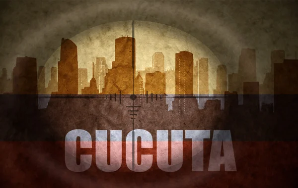 Sniper scope aimed at the abstract silhouette of the city with text Cucuta at the vintage colombian flag. concept — Zdjęcie stockowe